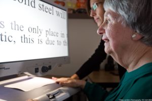 A woman in front of a monitor with magnified text