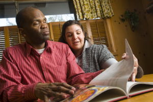 A volunteer reading to a visually impaired person