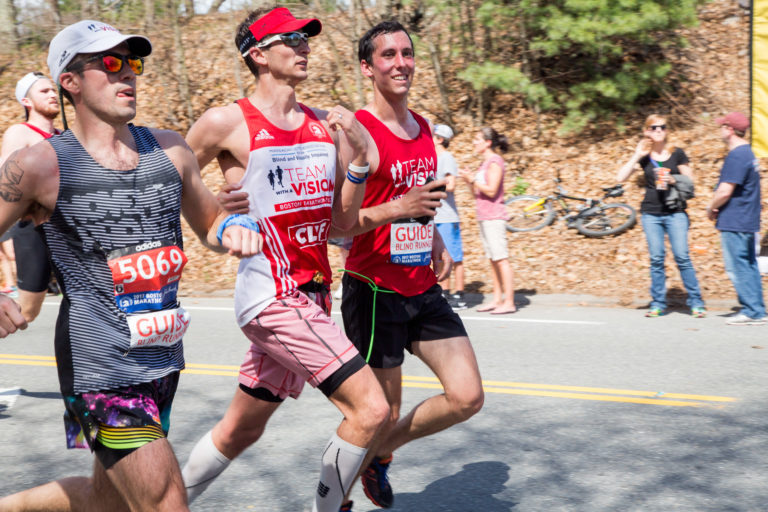 Visually impaired runner running next to his guide in the Boston Marathon