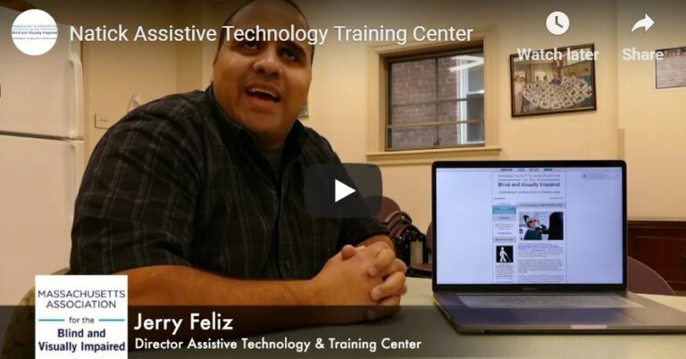 Jerry Feliz, Director of the Assistive Technology Training program sitting at a desk with laptop