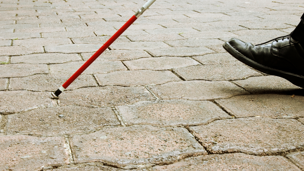 Closeup of man walking with white cane