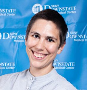Headshot of Eleanor Strehl, Director of Social Services. Image of a smiling person with short cropped hair, light colored complexion against a blue background.