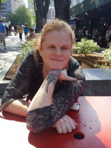 Sassy Outwater Wright smiling and leaning on her arm at a table outdoors